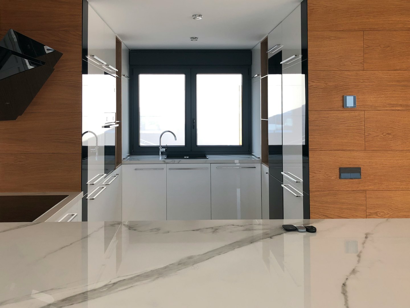 Cocina moderna con gabinetes blancos y encimera de mármol.
