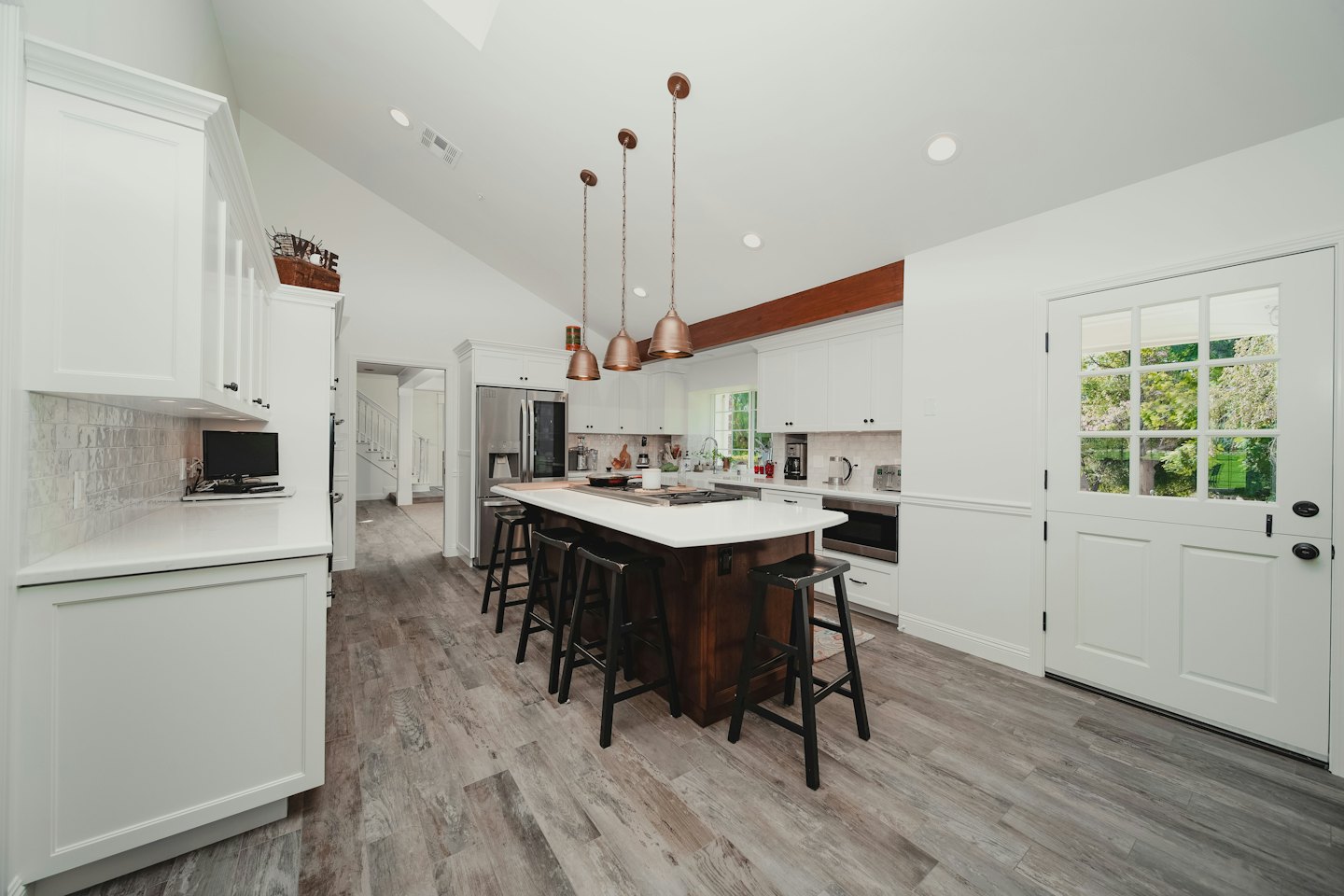 Cocina moderna con gabinetes blancos y una isla grande.