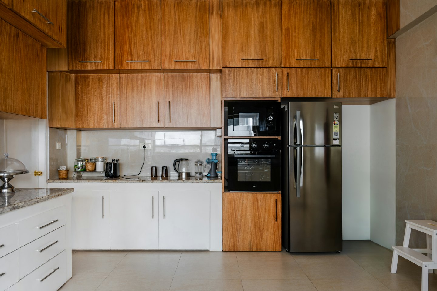 Cocina moderna con gabinetes de madera, encimeras de granito y electrodomésticos.